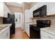 Galley kitchen featuring white cabinets, granite countertops, and stainless-steel appliances at 4694 S Fraser Ct # A, Aurora, CO 80015