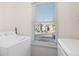 Laundry room with white washer and dryer, featuring a sunny window with community view at 4694 S Fraser Ct # A, Aurora, CO 80015