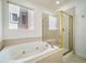 Bathroom with a soaking tub, a tiled shower with a glass door and a large window at 5191 S Hannibal Way, Centennial, CO 80015