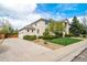 A spacious driveway leads to a two-car garage, complemented by mature landscaping, creating a welcoming entrance at 5191 S Hannibal Way, Centennial, CO 80015