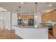 Well-lit kitchen with a large center island, stainless steel appliances, and wood cabinetry at 5191 S Hannibal Way, Centennial, CO 80015