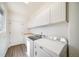 Well-lit laundry room featuring white cabinets and modern washer and dryer appliances at 5191 S Hannibal Way, Centennial, CO 80015