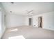An airy loft area with bright lighting, neutral carpeting, a ceiling fan and an open doorway to a bath at 5191 S Hannibal Way, Centennial, CO 80015