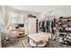 Well-lit bedroom with walk in closet, desk and tufted ottoman at 7586 Chase St, Arvada, CO 80003