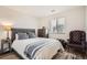 Cozy bedroom with a plush bed, accent chair, and a sunlit window at 7586 Chase St, Arvada, CO 80003