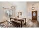 Bright dining area features a rustic table set, hardwood floors and natural light at 7586 Chase St, Arvada, CO 80003