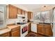 Cozy kitchen with wood cabinets and a large window above the sink offering an abundance of natural light at 7586 Chase St, Arvada, CO 80003