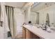 Bright bathroom features a tub/shower combo with a curtain, vanity, and neutral accents at 12835 Mayfair Way # C, Englewood, CO 80112
