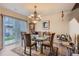Bright dining space with glass table, chandelier, and sliding doors to the backyard at 12835 Mayfair Way # C, Englewood, CO 80112