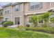 Back exterior view of a townhome with stone accents, a sliding glass door, and well-maintained landscaping at 12835 Mayfair Way # C, Englewood, CO 80112