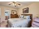 Comfortable main bedroom with wooden furnishings, a ceiling fan, and cozy quilt bedding at 12835 Mayfair Way # C, Englewood, CO 80112