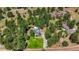 Expansive aerial view of the stone castle home surrounded by trees and open land at 6650 Village Rd, Parker, CO 80134