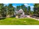 Stunning stone castle-style home with lush green lawn and mature trees at 6650 Village Rd, Parker, CO 80134