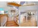 Open foyer with curved staircase, light wood floors, and views into dining room at 6650 Village Rd, Parker, CO 80134