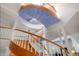 Unique spiral staircase with wood and white railing and painted ceiling at 6650 Village Rd, Parker, CO 80134