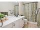 Bathroom featuring double sinks, patterned shower curtain, and neutral colors at 10096 Hughes Pl, Highlands Ranch, CO 80126