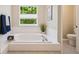 Bright white bathroom with soaking tub overlooking the trees, a tranquil and luxurious escape at 10096 Hughes Pl, Highlands Ranch, CO 80126