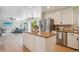Kitchen with granite island, stainless steel appliances and white cabinets, with a view into the living room at 10096 Hughes Pl, Highlands Ranch, CO 80126
