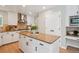 Modern kitchen featuring an island with granite countertops, white cabinetry and tile backsplash at 10096 Hughes Pl, Highlands Ranch, CO 80126