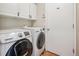 Bright laundry room with white cabinets and modern washer and dryer at 10096 Hughes Pl, Highlands Ranch, CO 80126