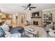 Open floor plan with brick fireplace in the living room, next to a modern kitchen and breakfast nook at 10096 Hughes Pl, Highlands Ranch, CO 80126
