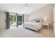 Spacious main bedroom with access to a private balcony overlooking trees, light carpet, and neutral paint at 10096 Hughes Pl, Highlands Ranch, CO 80126