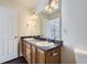 Bathroom featuring a double vanity, wood cabinets, dark counters, and modern fixtures at 20000 E Mitchell Pl # 35, Denver, CO 80249