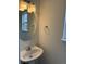 Cozy half bathroom features a pedestal sink and a round mirror at 20000 E Mitchell Pl # 35, Denver, CO 80249