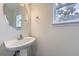 Bathroom featuring pedestal sink, round mirror, and window with natural light at 20000 E Mitchell Pl # 35, Denver, CO 80249