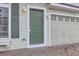 Close-up view of a well-maintained home with a green front door and a brick driveway at 20000 E Mitchell Pl # 35, Denver, CO 80249