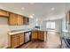 Open kitchen with stainless steel appliances, granite counters, wood cabinets, and wood flooring at 20000 E Mitchell Pl # 35, Denver, CO 80249