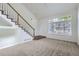 Bright living room featuring stairs, neutral carpeting and a large window at 20000 E Mitchell Pl # 35, Denver, CO 80249
