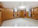 Spacious basement area featuring wood paneled walls, drop ceiling, and natural light at 209 S 13Th Ave, Brighton, CO 80601