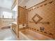 A full bathroom featuring a tub with grab bars and a patterned tile wall at 209 S 13Th Ave, Brighton, CO 80601