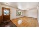 Living room featuring hardwood floors, a window, and a classic entry door at 209 S 13Th Ave, Brighton, CO 80601