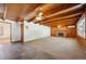 Spacious living room with wood paneling, beamed ceiling, fireplace, and large window at 209 S 13Th Ave, Brighton, CO 80601