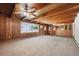 Spacious living room with wood paneling, beamed ceiling, ceiling fan, and large window at 209 S 13Th Ave, Brighton, CO 80601