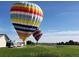 Image captures vibrant hot air balloons preparing for flight in a lush, green field at 4627 Cathy Ln, Erie, CO 80516
