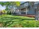 Charming home featuring a backyard with green grass, mature trees, and an inviting porch at 902 Grove Dr, Louisville, CO 80027