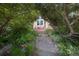Stone pathway leads to a cozy front entrance with red chairs, framed by lush greenery and mature trees at 902 Grove Dr, Louisville, CO 80027