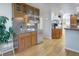 Stylish bar area features a sink, mini-fridge, glassware display and leads to the kitchen at 902 Grove Dr, Louisville, CO 80027