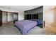 Bedroom featuring carpet, a colorful bedspread, mirrored closet doors, and custom shelving at 10311 E Evans Ave # 133, Aurora, CO 80247