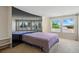 Bright bedroom featuring carpet, a colorful bedspread, and a mirrored wall that reflects the bright, natural light at 10311 E Evans Ave # 133, Aurora, CO 80247