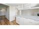 Modern kitchen with wood floors, white cabinets, and island featuring a light countertop at 10311 E Evans Ave # 133, Aurora, CO 80247