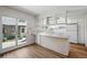 Bright kitchen with white cabinets, island featuring a light countertop, and a door to the yard at 10311 E Evans Ave # 133, Aurora, CO 80247
