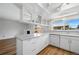 Bright kitchen with wood floors, white cabinets, and an island with light countertop at 10311 E Evans Ave # 133, Aurora, CO 80247