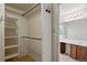 Walk-in closet with custom shelving, a view of the vanity, and bright lighting at 10311 E Evans Ave # 133, Aurora, CO 80247