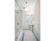 Well-lit, white-tiled bathroom with a vintage-style sink and bathtub, plus honeycomb floor at 1429 Josephine St, Denver, CO 80206
