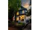 Charming home with a welcoming front porch and mature trees at dusk at 1429 Josephine St, Denver, CO 80206