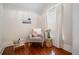 Charming sitting nook with a rocking chair, soft textures, and wood stump side table by the window at 1429 Josephine St, Denver, CO 80206